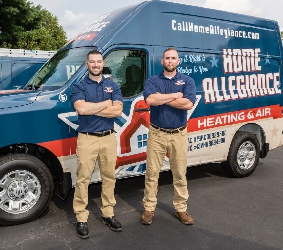 Two Home Allegiance technicians standing in front of their branded van